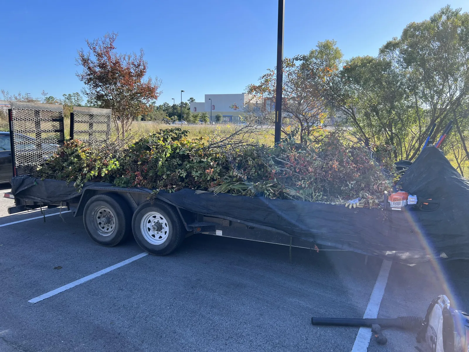 Trailer heaped with cut brush and limbs ready to haul off